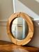 Round mirror in raw wood
