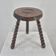 Brutalist tripod stool made of solid turned wood.