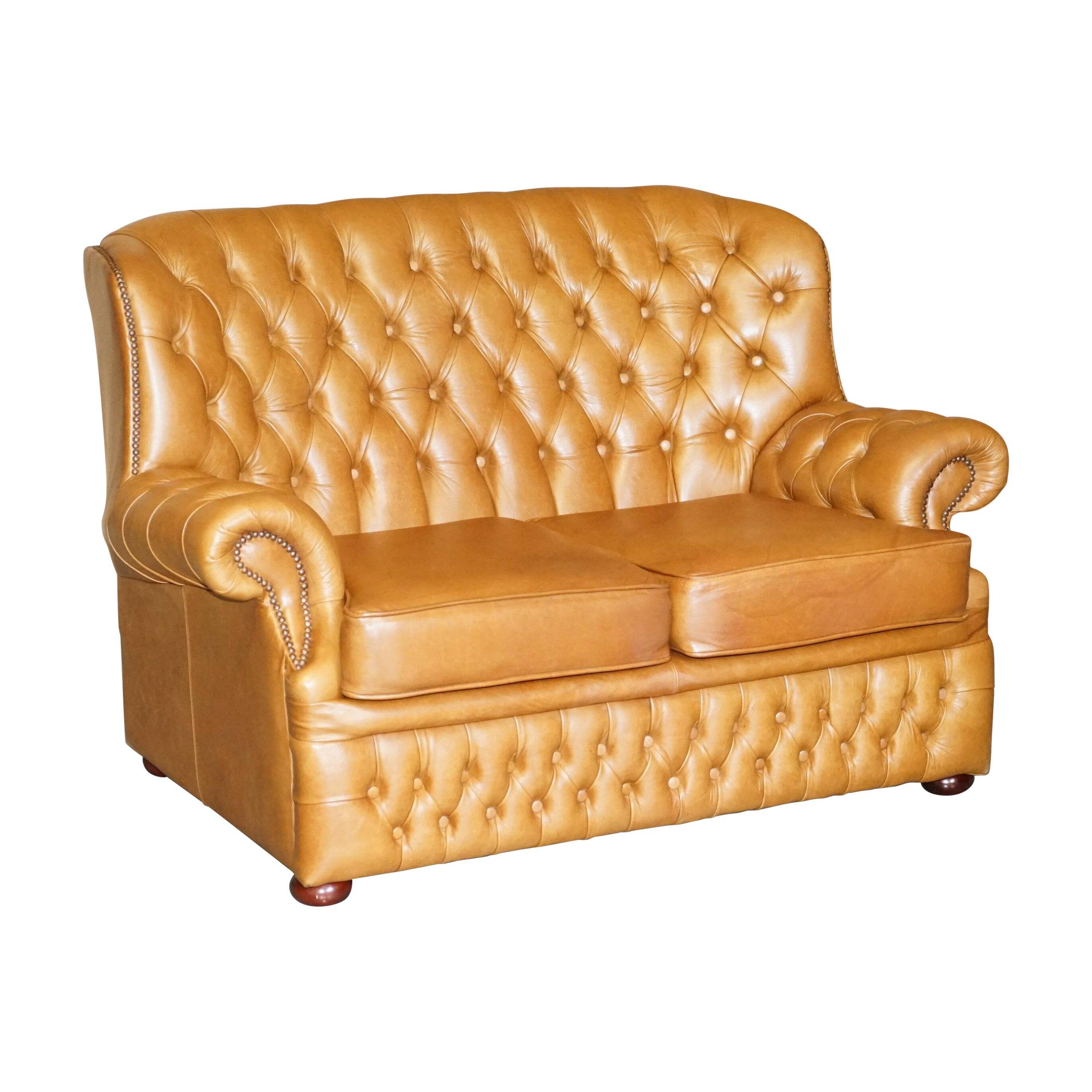 Small Chesterfield leather sofa with a high back.