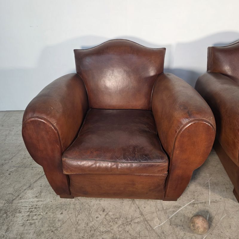 Important pair of Havana leather club armchairs, moustache models, mid-20th century.
