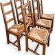 Set of 6 wooden chairs with straw seats and high backs.
