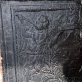 huge old fireplace plate has decoration of angels, crown and fleurs-de-lis