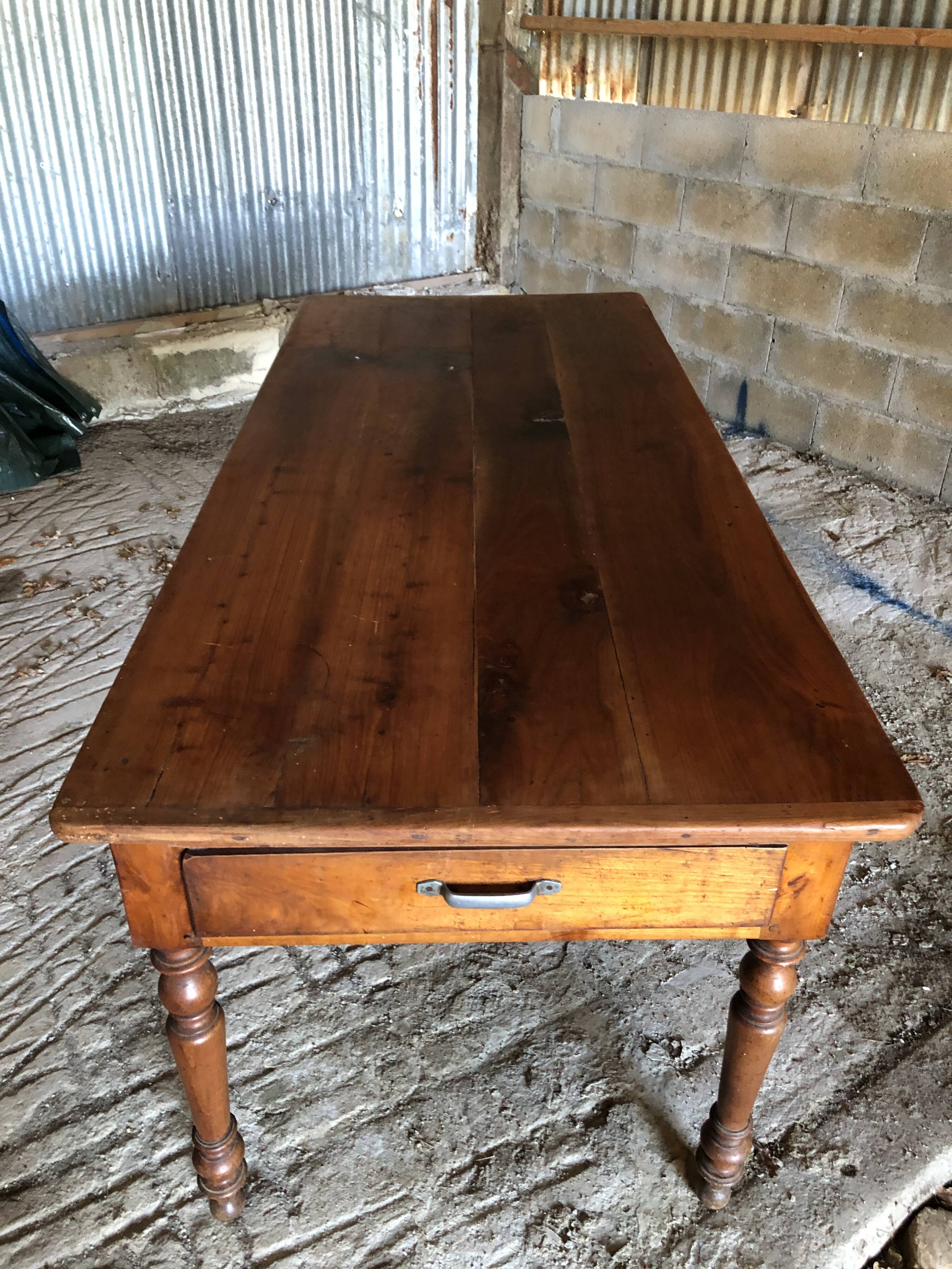 Antique Louis Philippe style farm table in solid cherry wood with turned base.