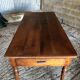 Antique Louis Philippe style farm table in solid cherry wood with turned base.