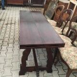 19th-century brown walnut dining table with sculpted trestle legs.