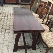 19th-century brown walnut dining table with sculpted trestle legs.