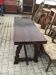 19th-century brown walnut dining table with sculpted trestle legs.