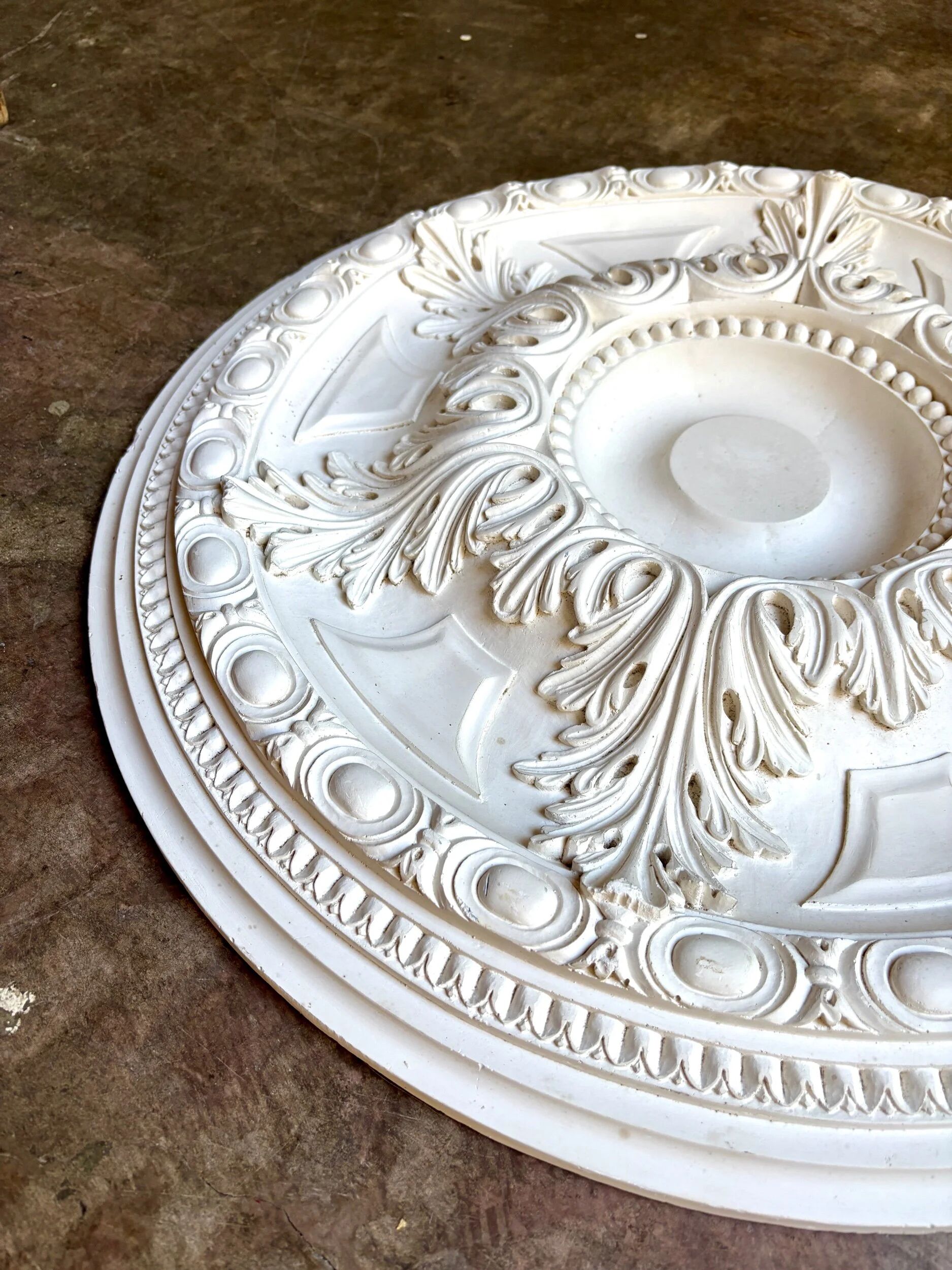 Rosette on white background, decorated with scrolls and beaded frieze ⌀ 61 cm