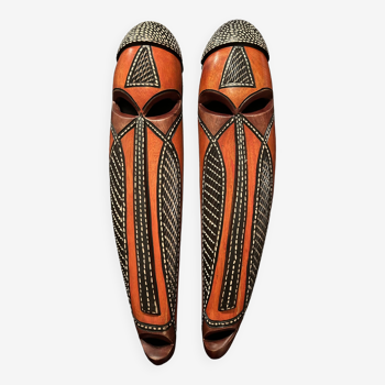 Elegant duo of carved wooden masks with traditional african motifs