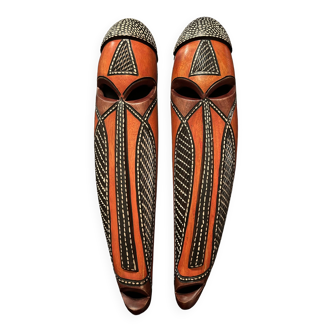 Elegant duo of carved wooden masks with traditional african motifs