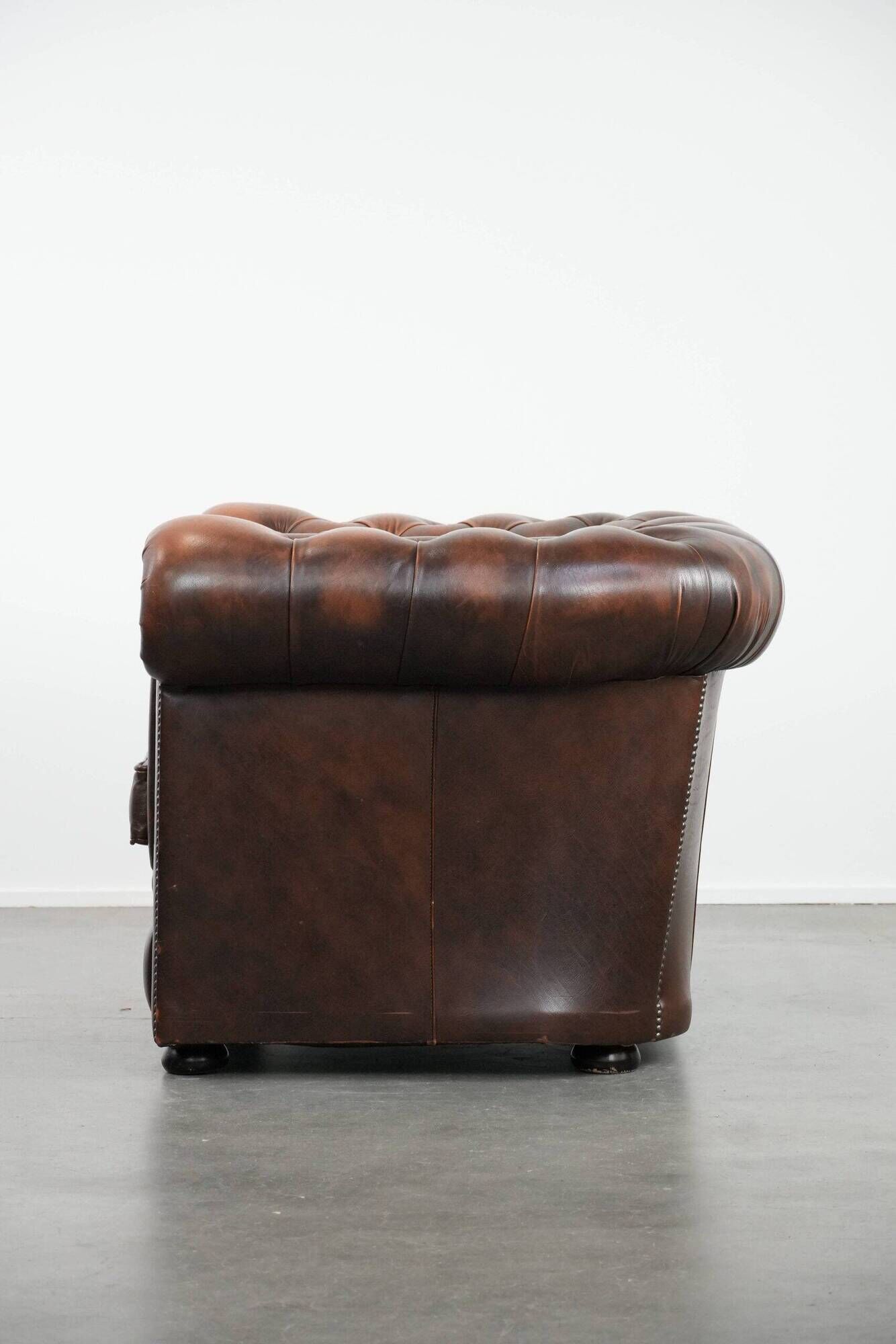 Brown Chesterfield armchair made of cowhide leather in English style