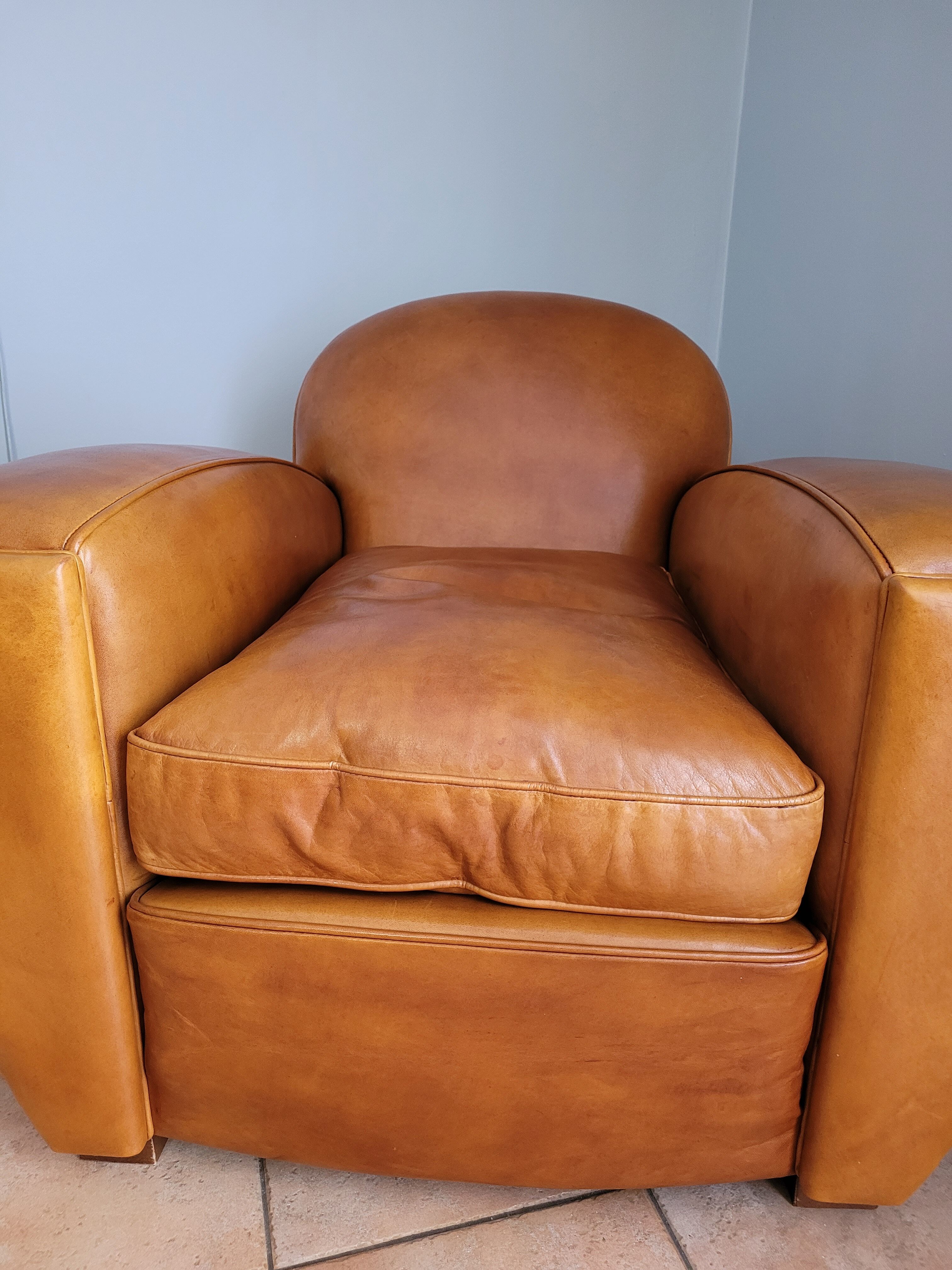 Leather club armchair and its pouf