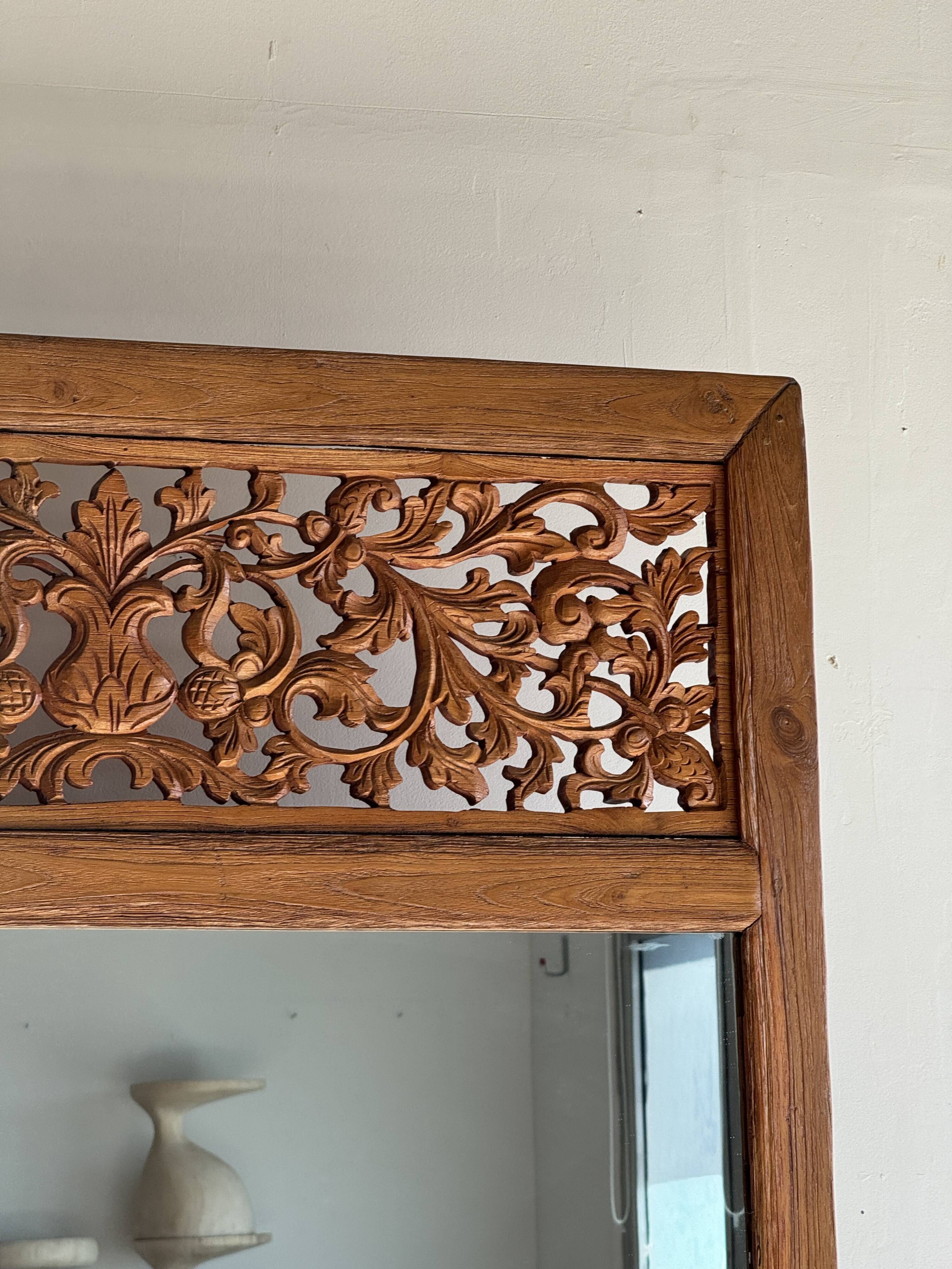 Very large freestanding teak mirror with an openwork carved pediment, Indonesia.