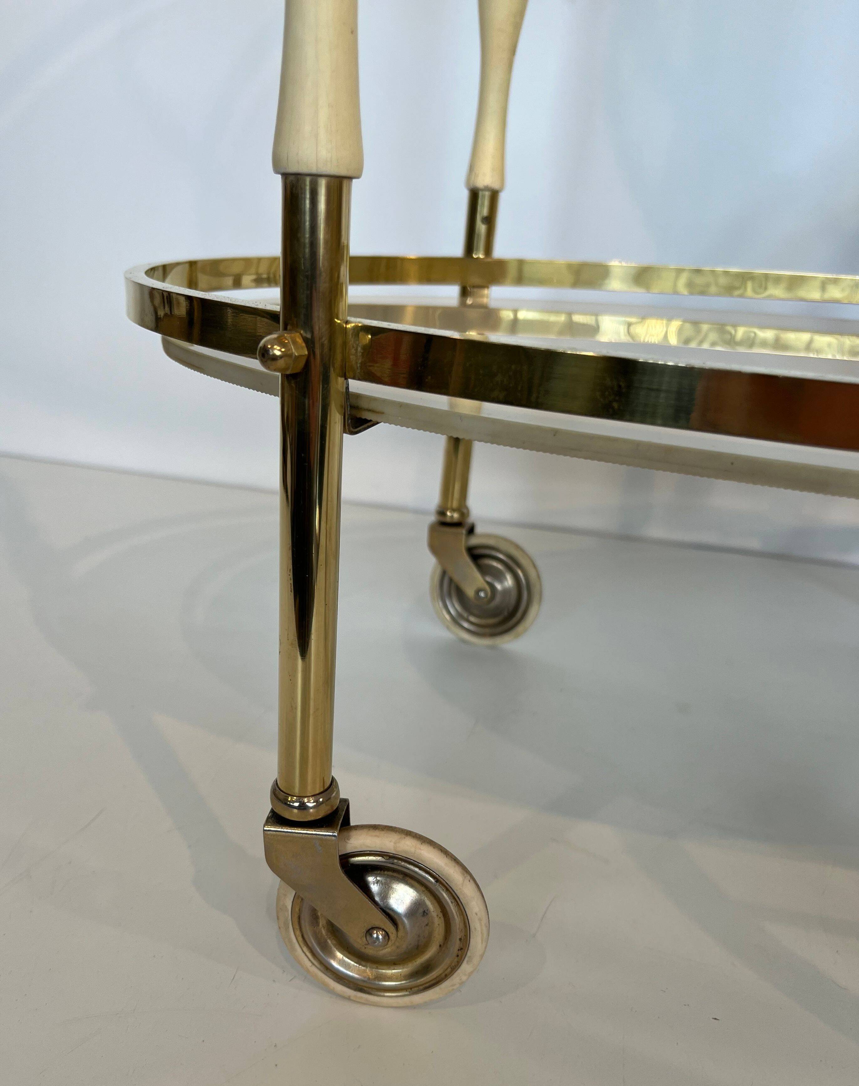 Italian oval rolling table in brass and lacquered wood.