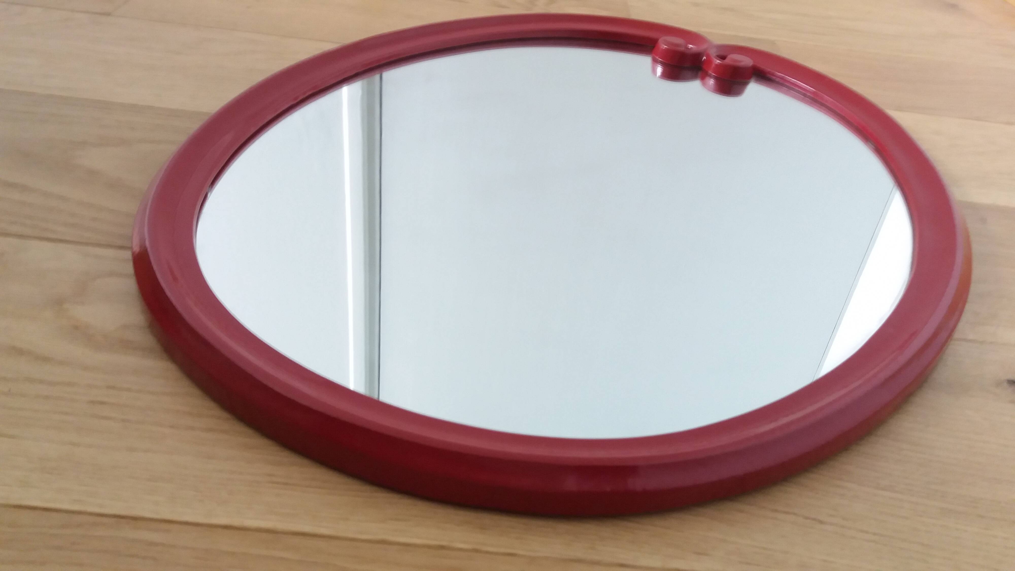 Oval mirror, red enamelled metal in Art Deco style, 49 x 39 cm.