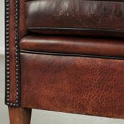 Vintage sheepskin club armchair with decorative nails and black piping