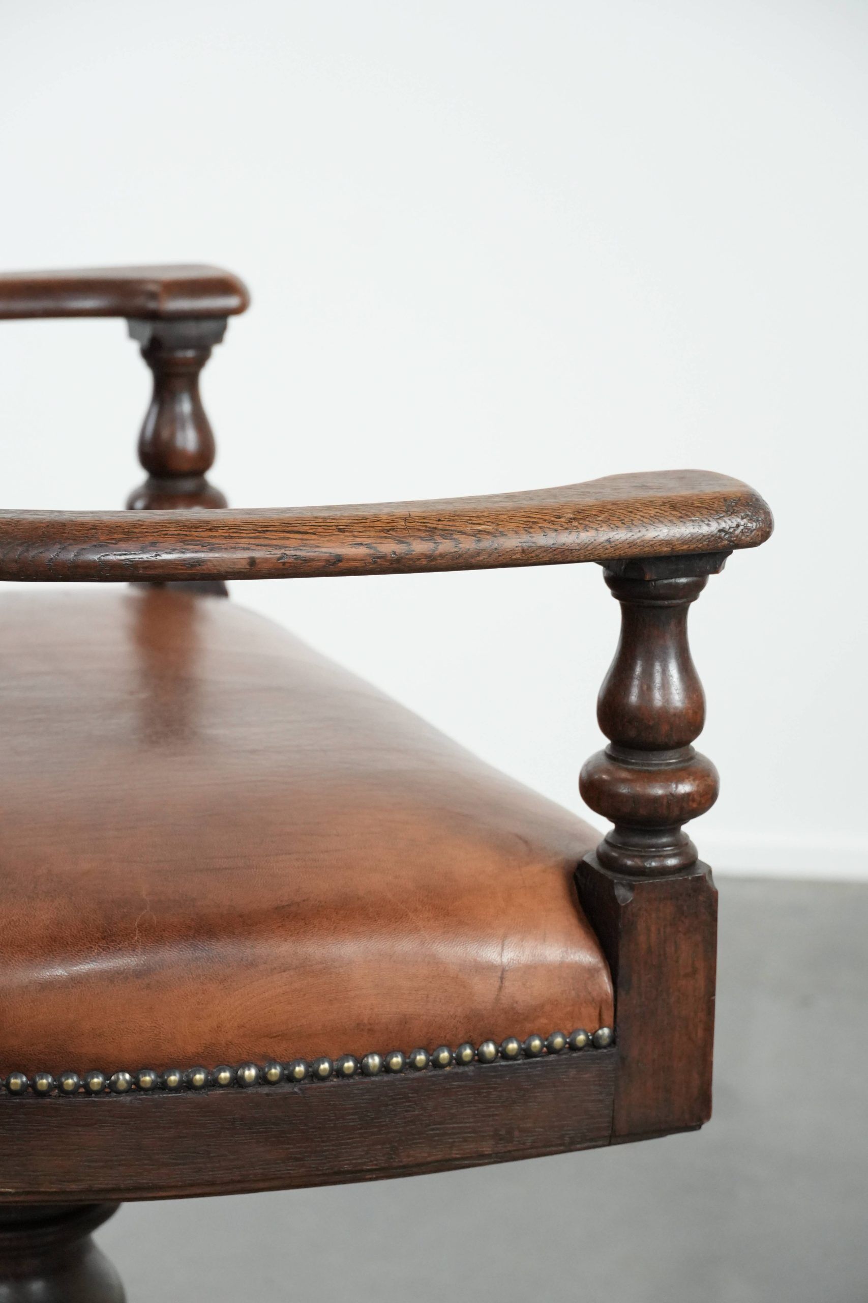 Elegant antique sheepskin leather desk chair with a heavy wooden frame