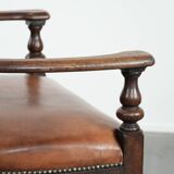 Elegant antique sheepskin leather desk chair with a heavy wooden frame