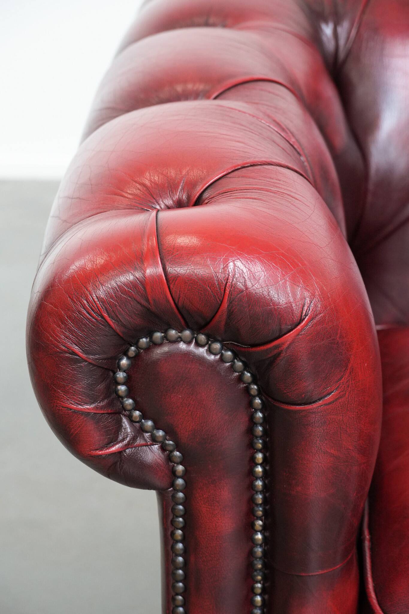 Red English cowhide Chesterfield armchair finished with decorative nails