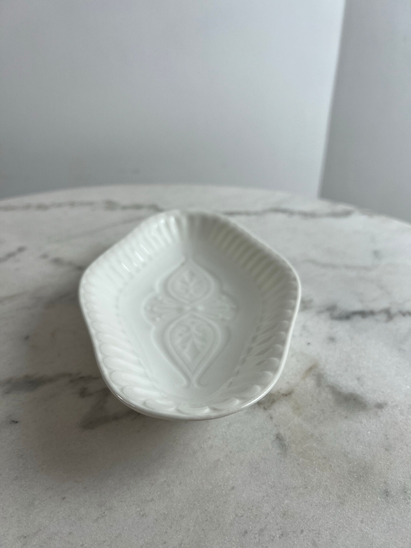 Oval white porcelain ramekin — raised floral pattern