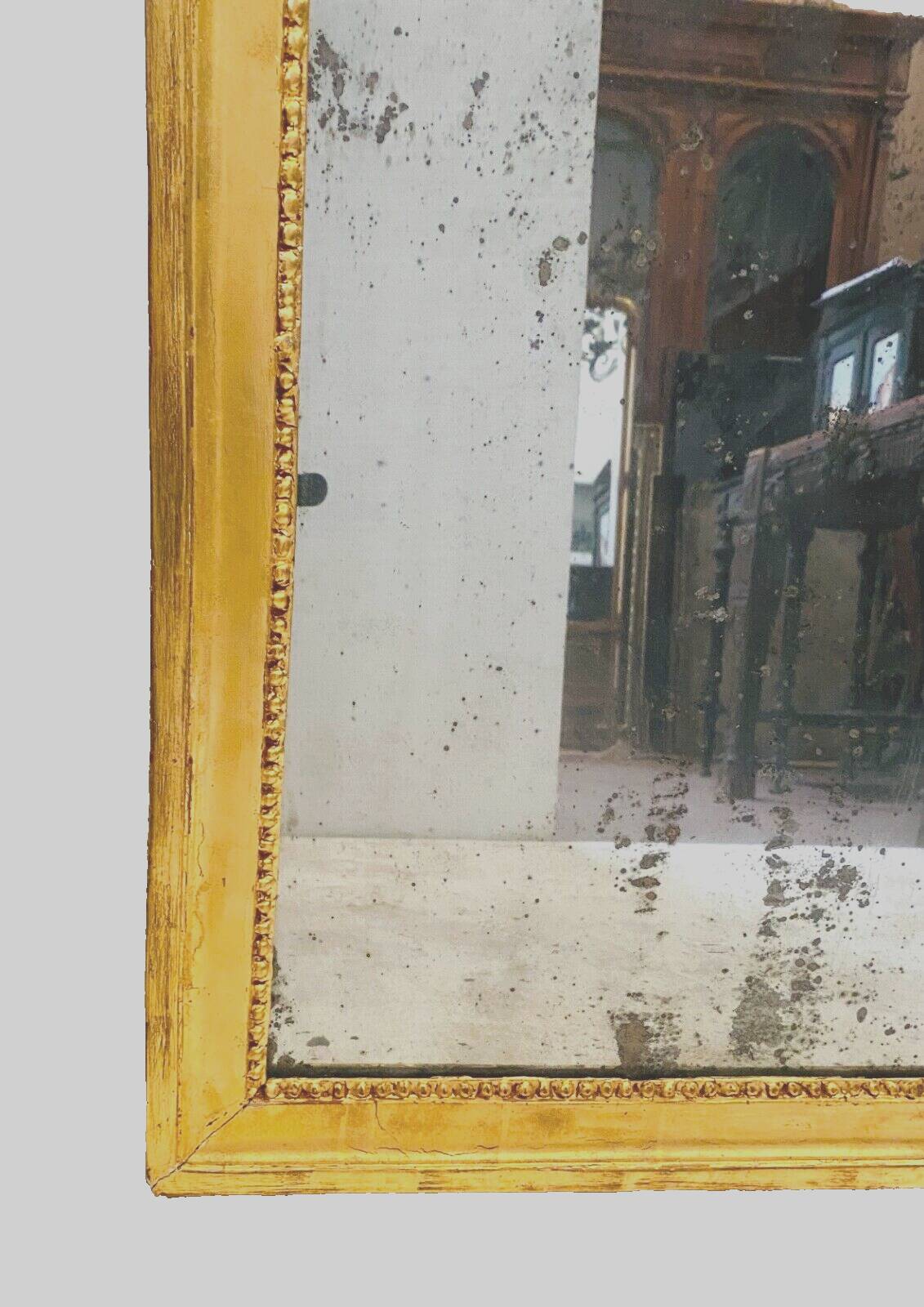 Louis XVI mirror in carved and gilded wood with leaf 18th century