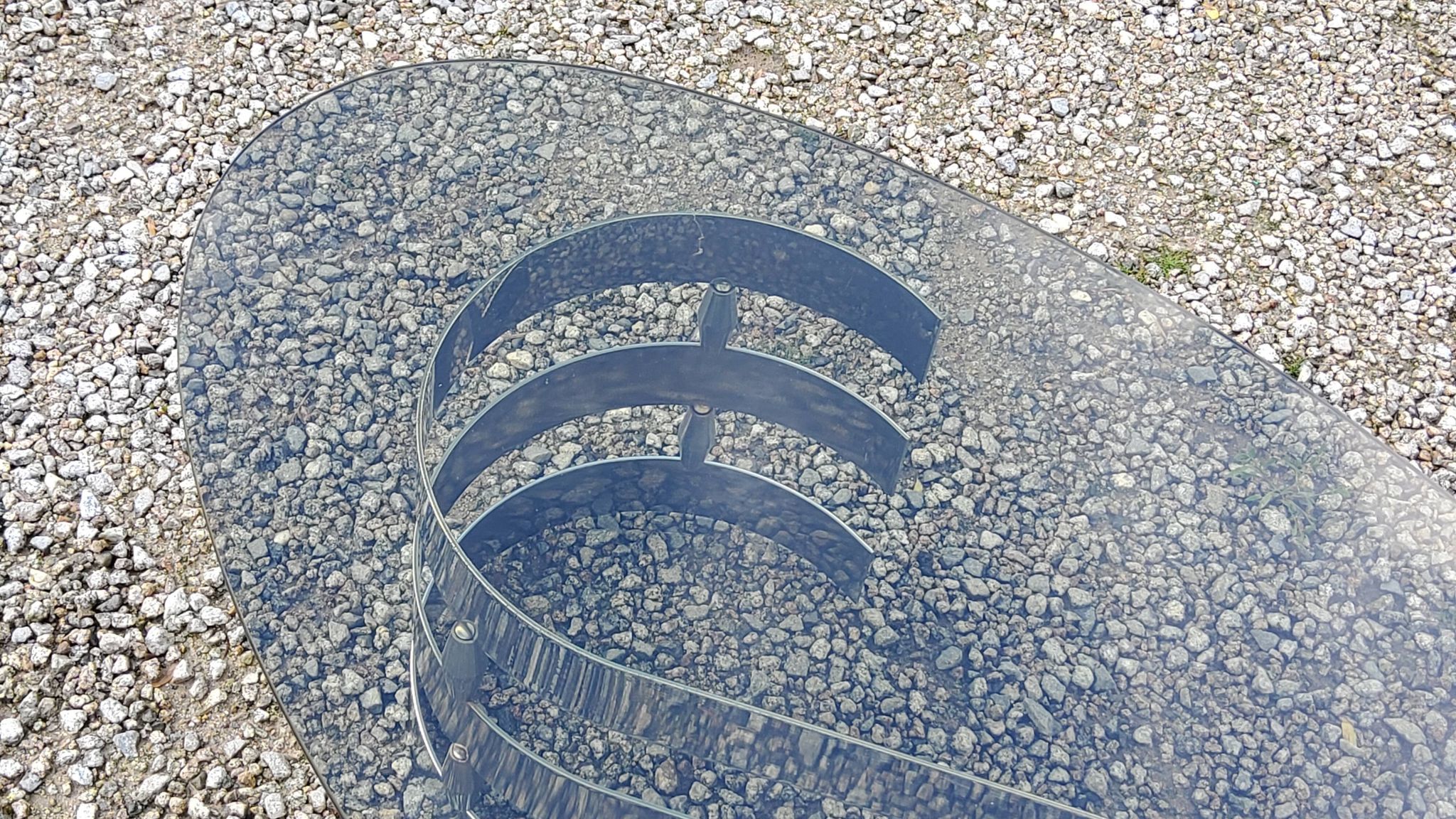 Oval coffee table of the 70s chromed metal base in s smoked glass top