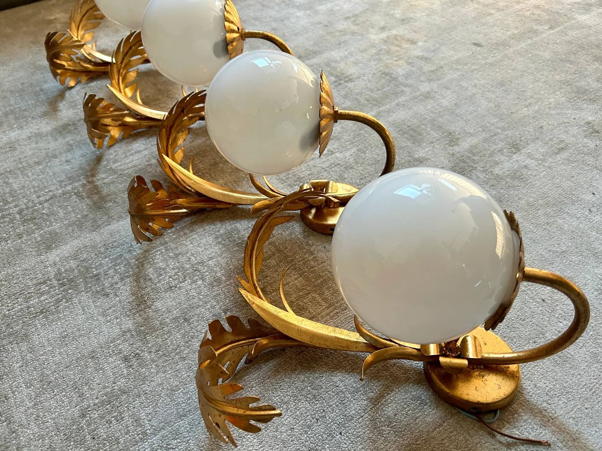 Pair of palm leaf wall lights in Hollywood Regency style with opaque globes by Hans Kögl, Germany, 1970s.