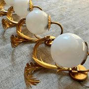 Pair of palm leaf wall lights in Hollywood Regency style with opaque globes by Hans Kögl, Germany, 1970s.