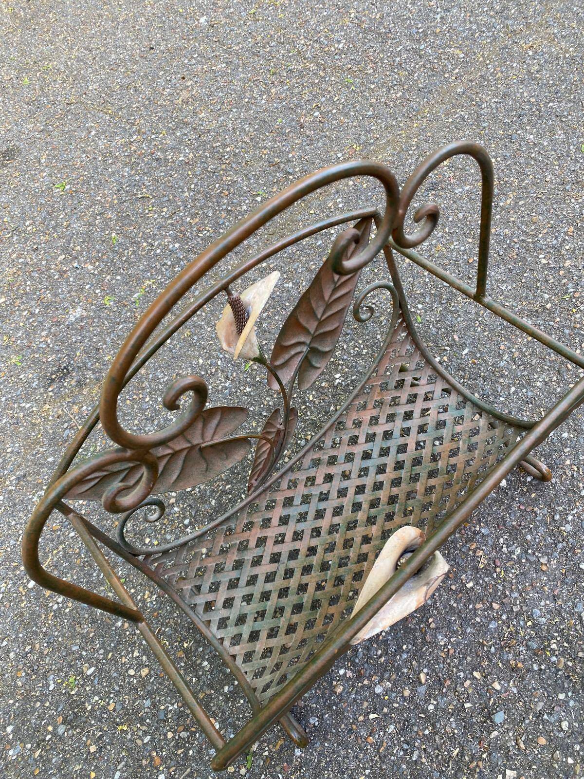Vintage wrought iron magazine rack with flower pattern.