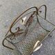 Vintage wrought iron magazine rack with flower pattern.