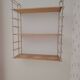 Vintage modular wall shelf in golden steel wire and wood from the 1950s.