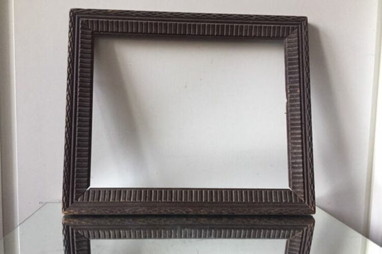 Antique wooden frame with geometric carvings light distress