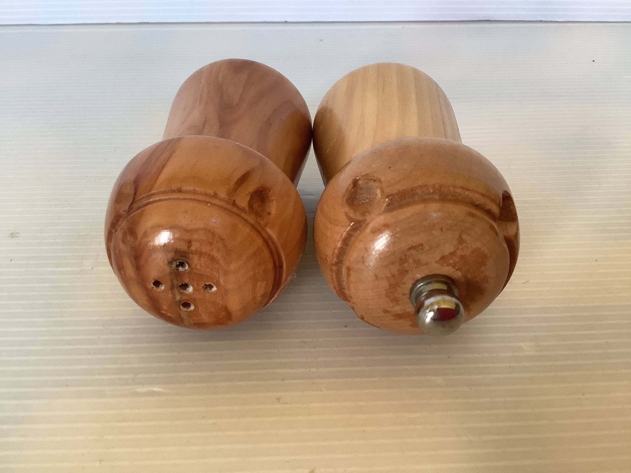 Salt and pepper shakers in wood shaped like a champagne cork.