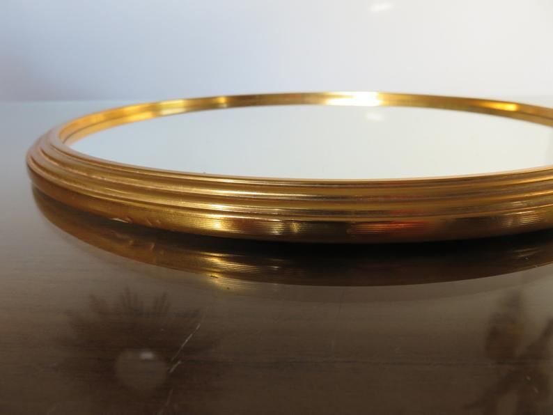 Round mirror tray in 1950s gold metal