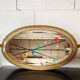 Antique oval mirror with a gilded frame, bevelled glass.