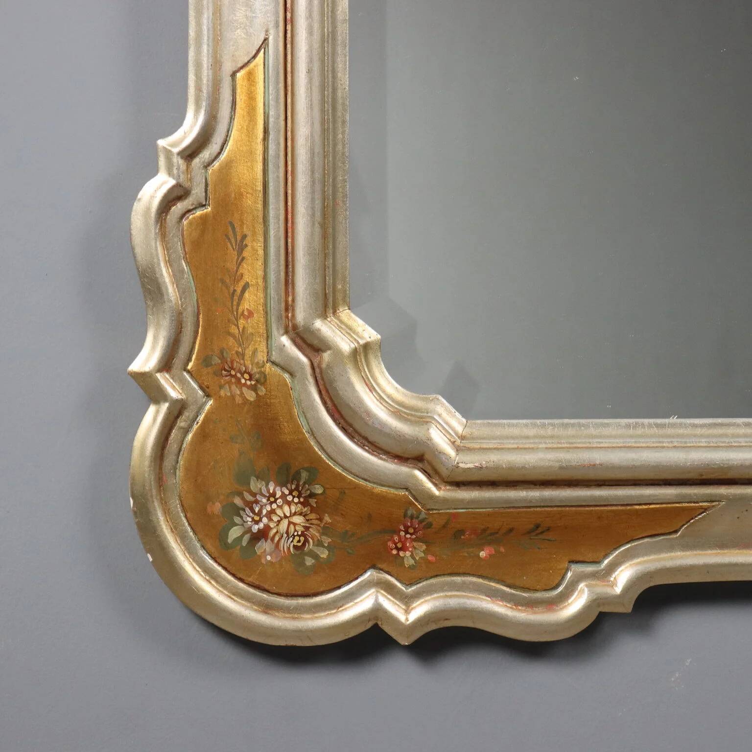 Antique mirror with a gilded frame and floral decorations, Italy, 20th century.