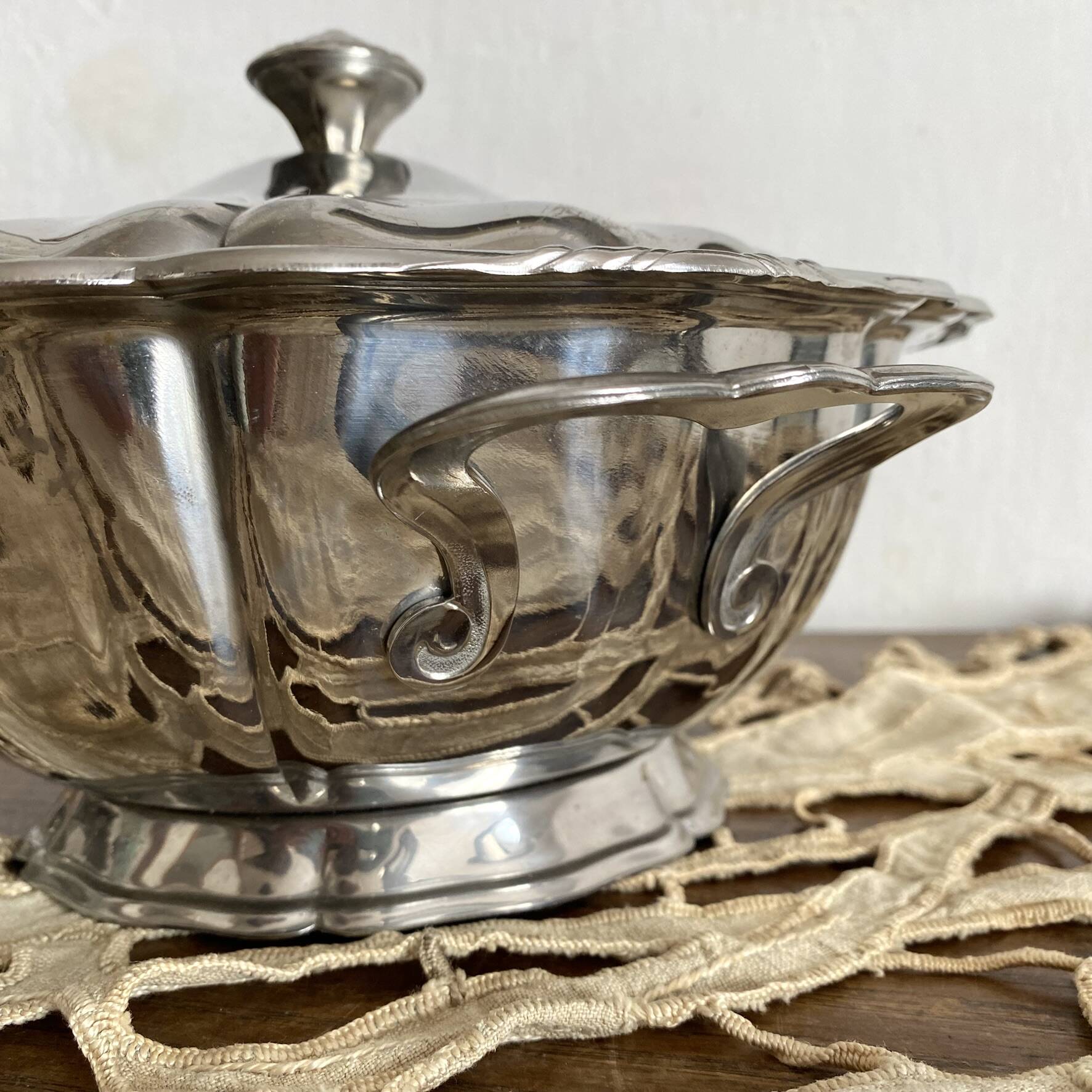 Vintage round stainless steel soup tureen with scalloped edges.