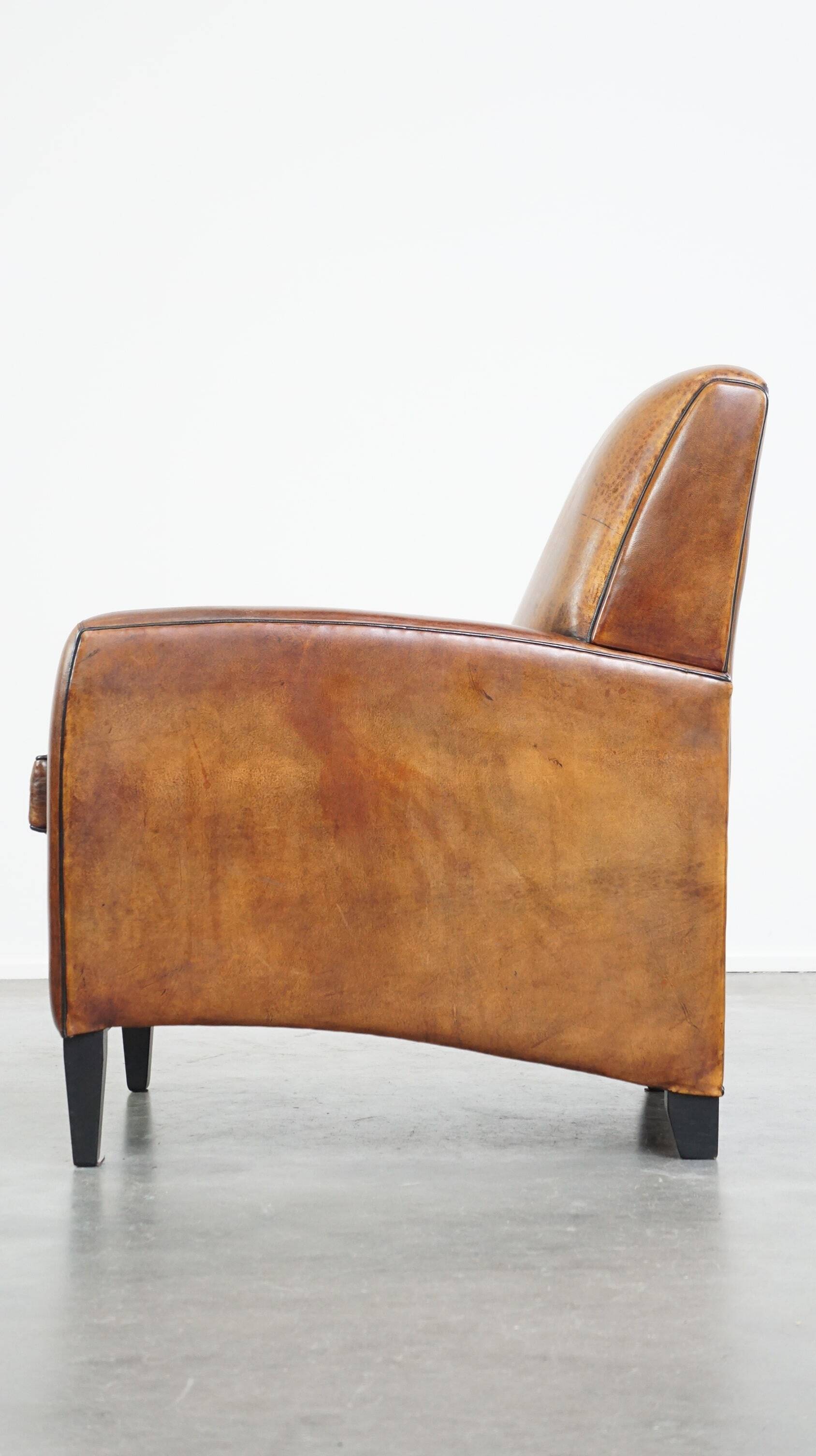 Art Deco design sheepskin leather armchair with a stunning patina