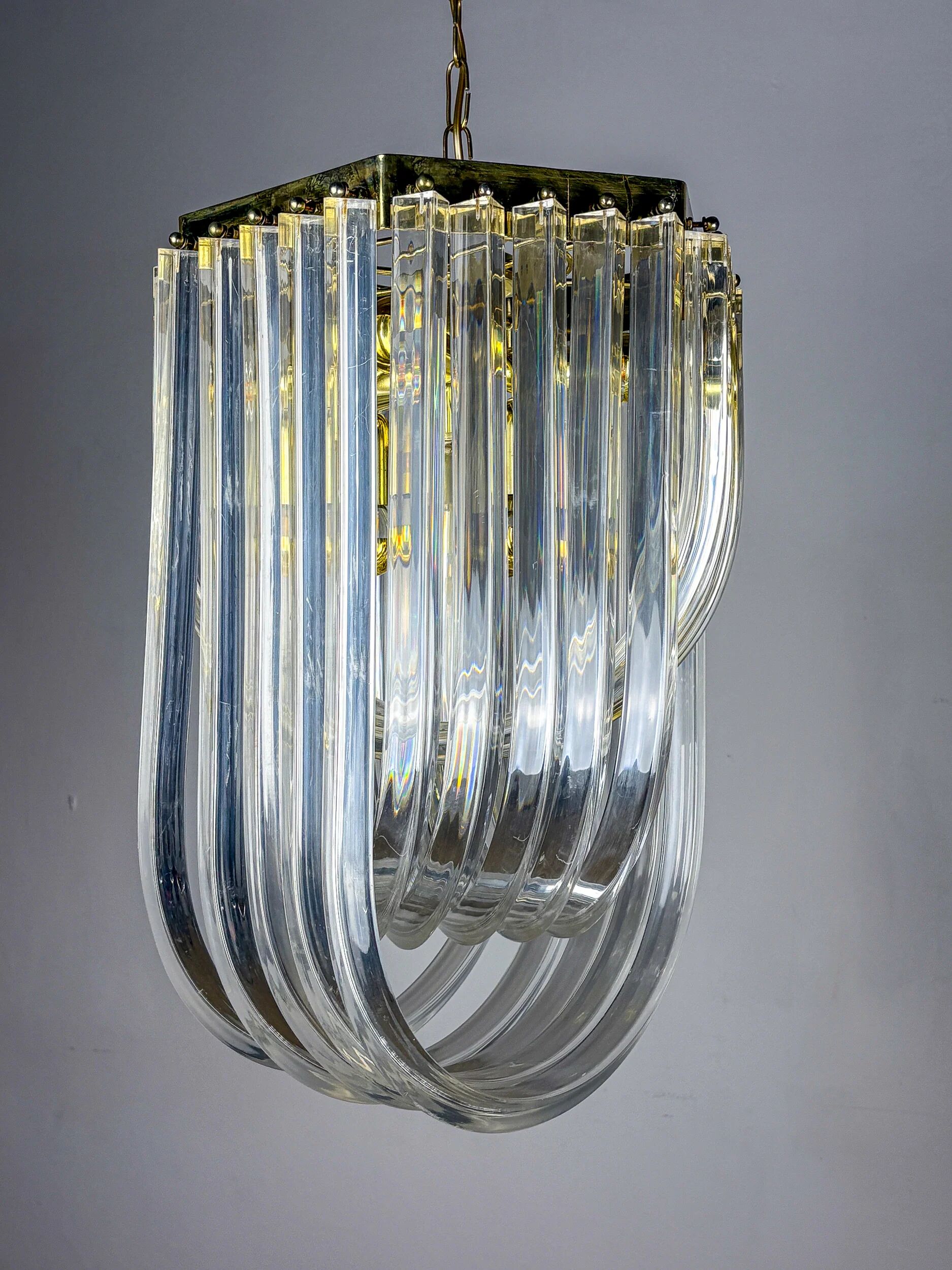 Long mid-century curved Lucite ribbon chandelier in brass, Italy