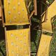 2 vintage Chilean deck chairs made of wood and yellow fabric printed with sailboats, with footrests.