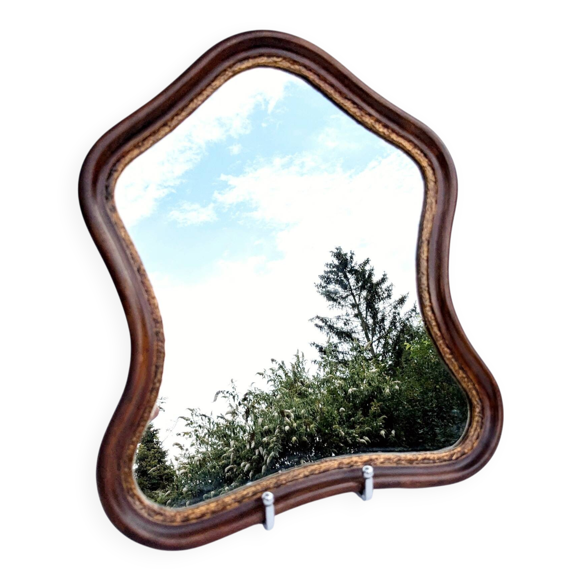 Antique wall mirror in carved wood with a wavy shape and a golden trim.