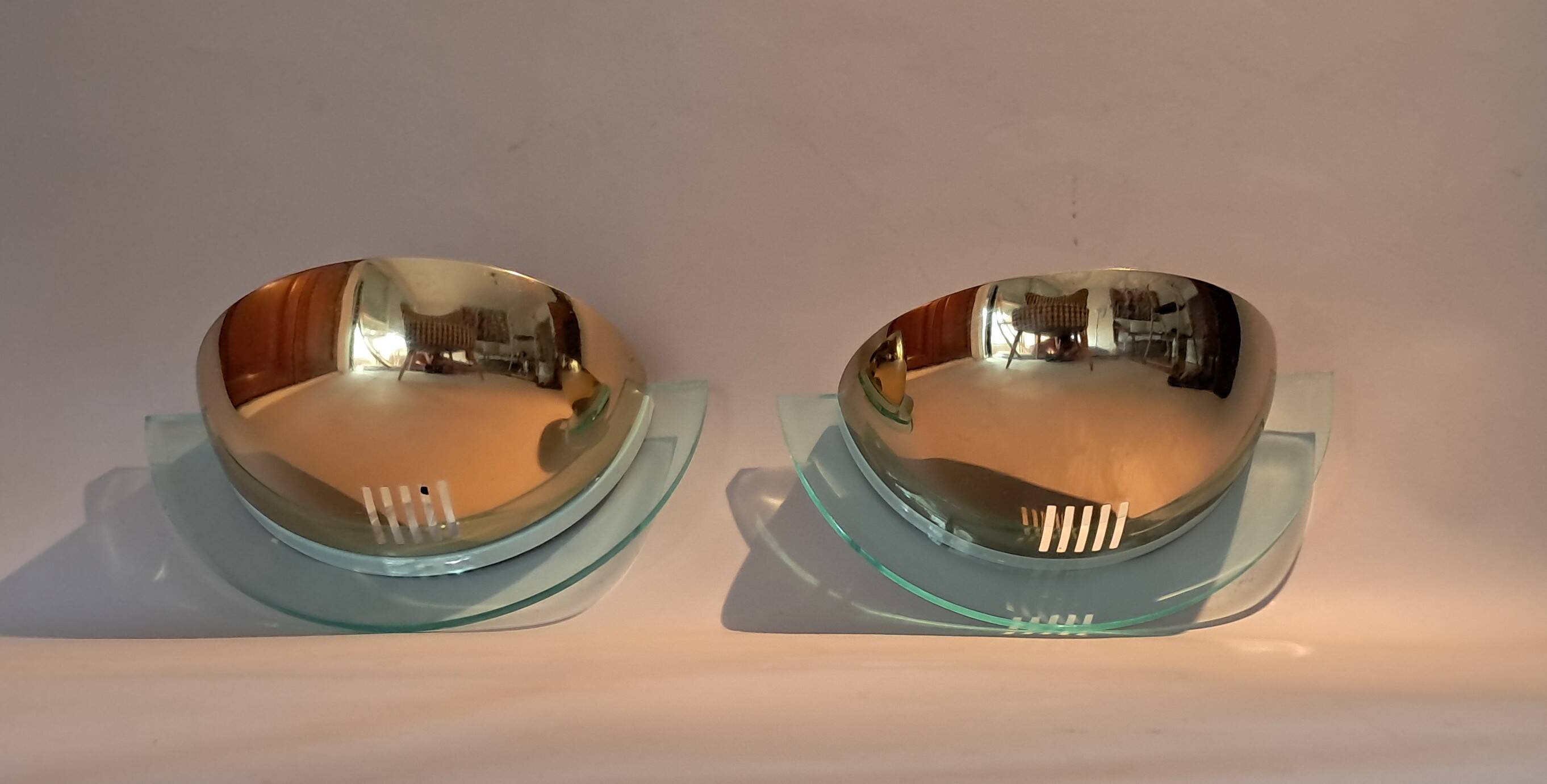 Pair of gold metal and plexiglass wall lights, circa 1980.