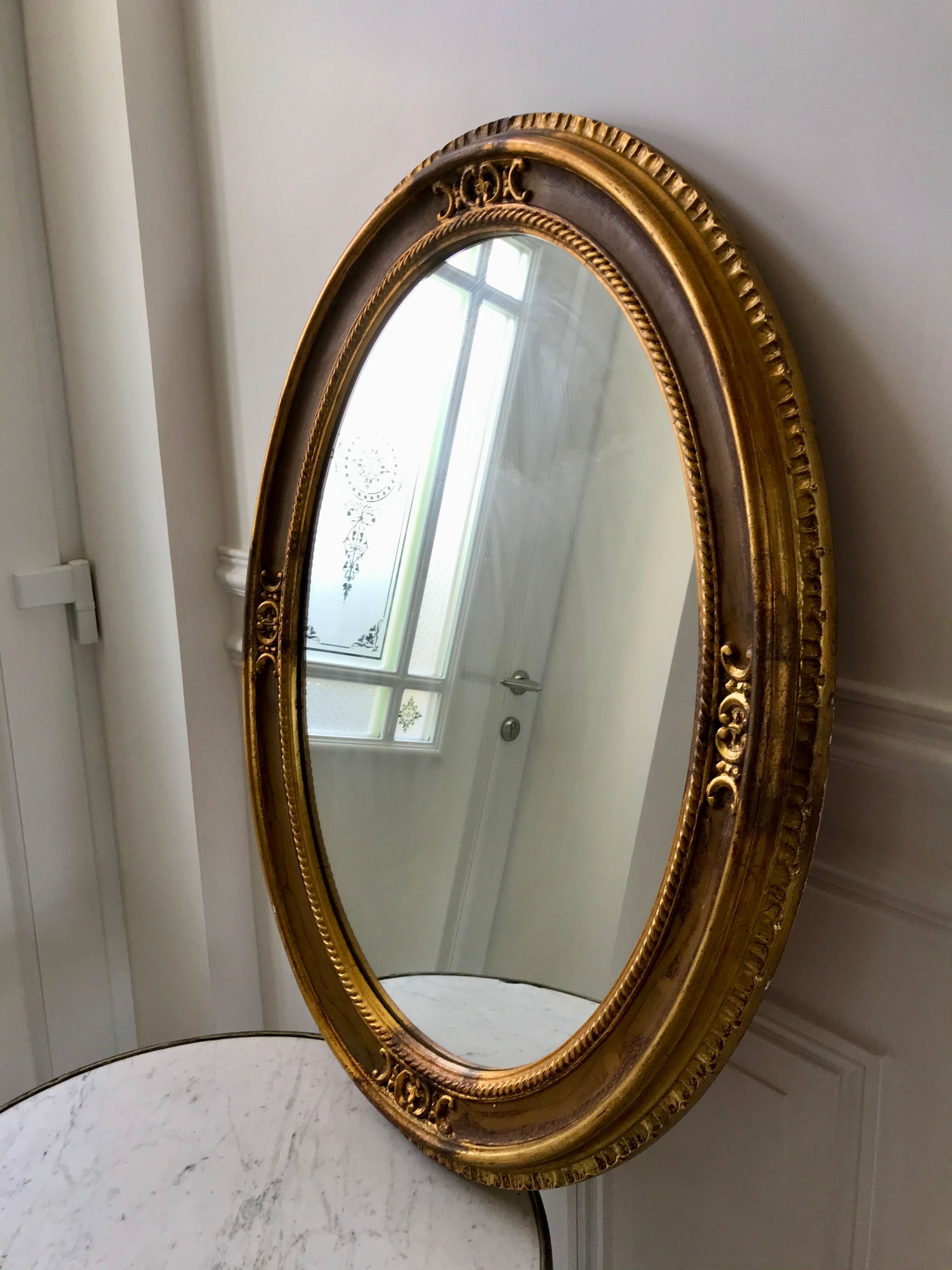 Grand miroir oval en stuc doré vintage
