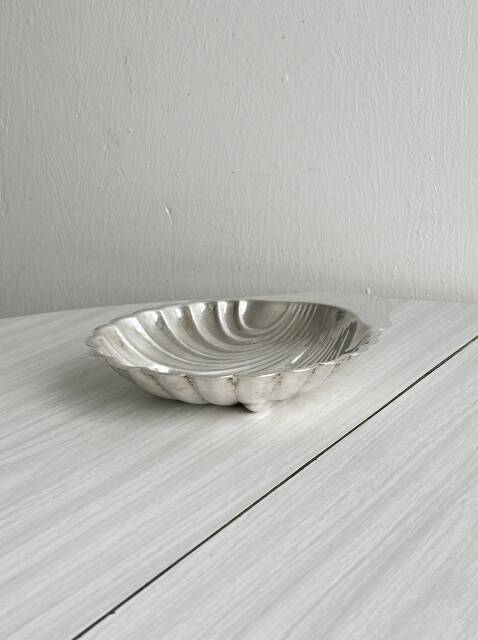 Old metal plate in the shape of a shell.