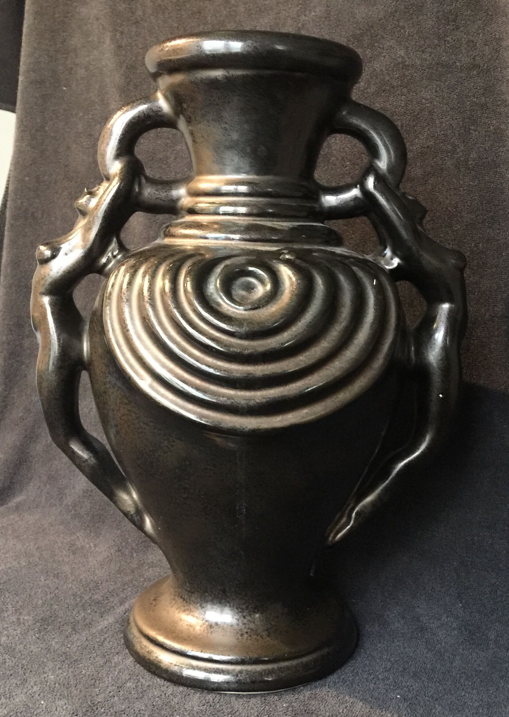 Black ceramic vase caught in naked women's bodies