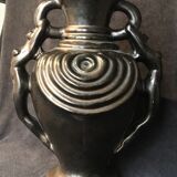 Black ceramic vase caught in naked women's bodies