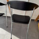 Set of two metal chairs with a brushed finish and black leather.