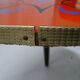 Plant holder tripod in geometrically patterned orange formica