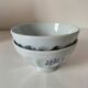 Two vintage farm bowls on a pale blue pedestal with floral decoration.
