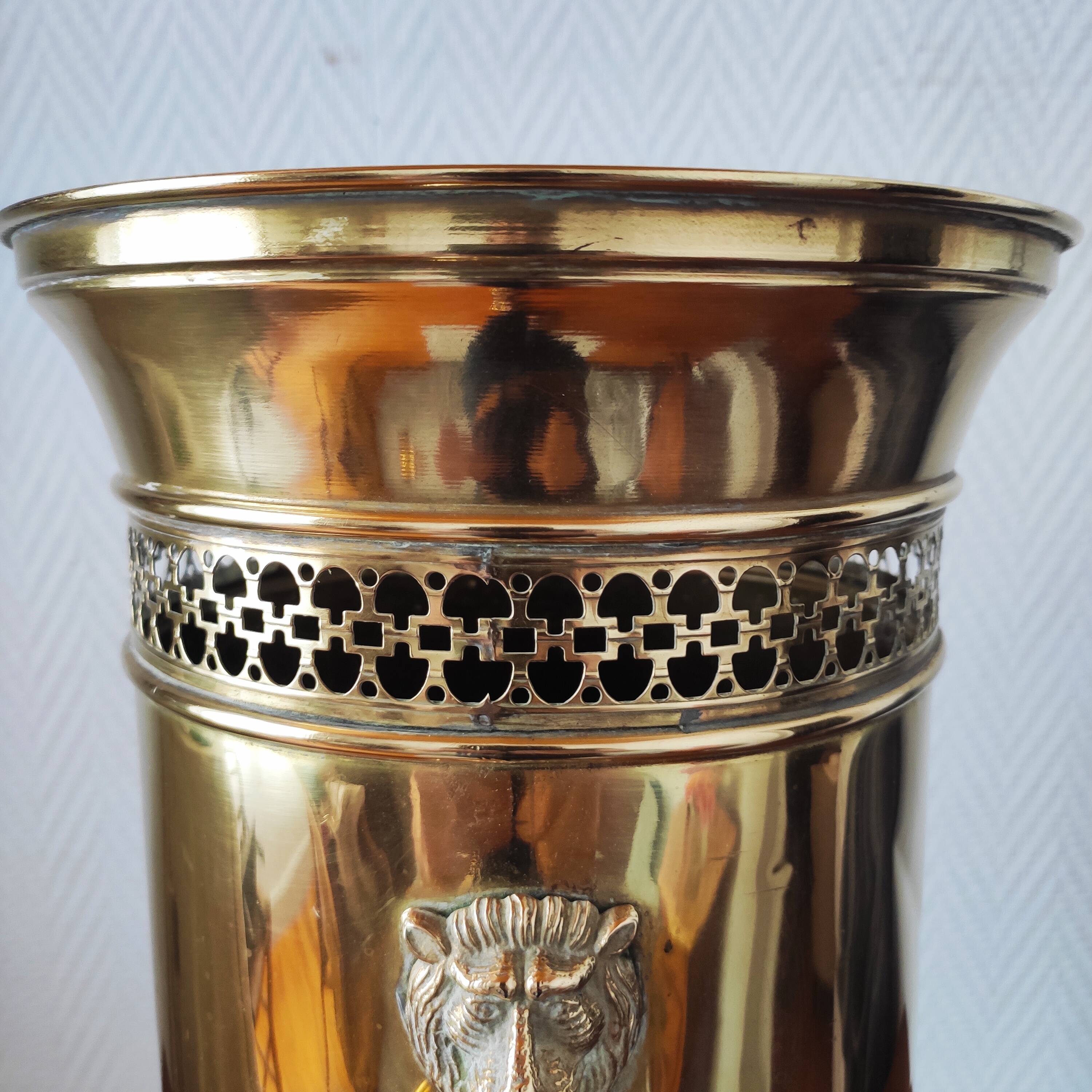 Vintage brass umbrella stand with lion decoration.